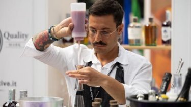 A bartender pouring liquid into a jigger at imbibe live